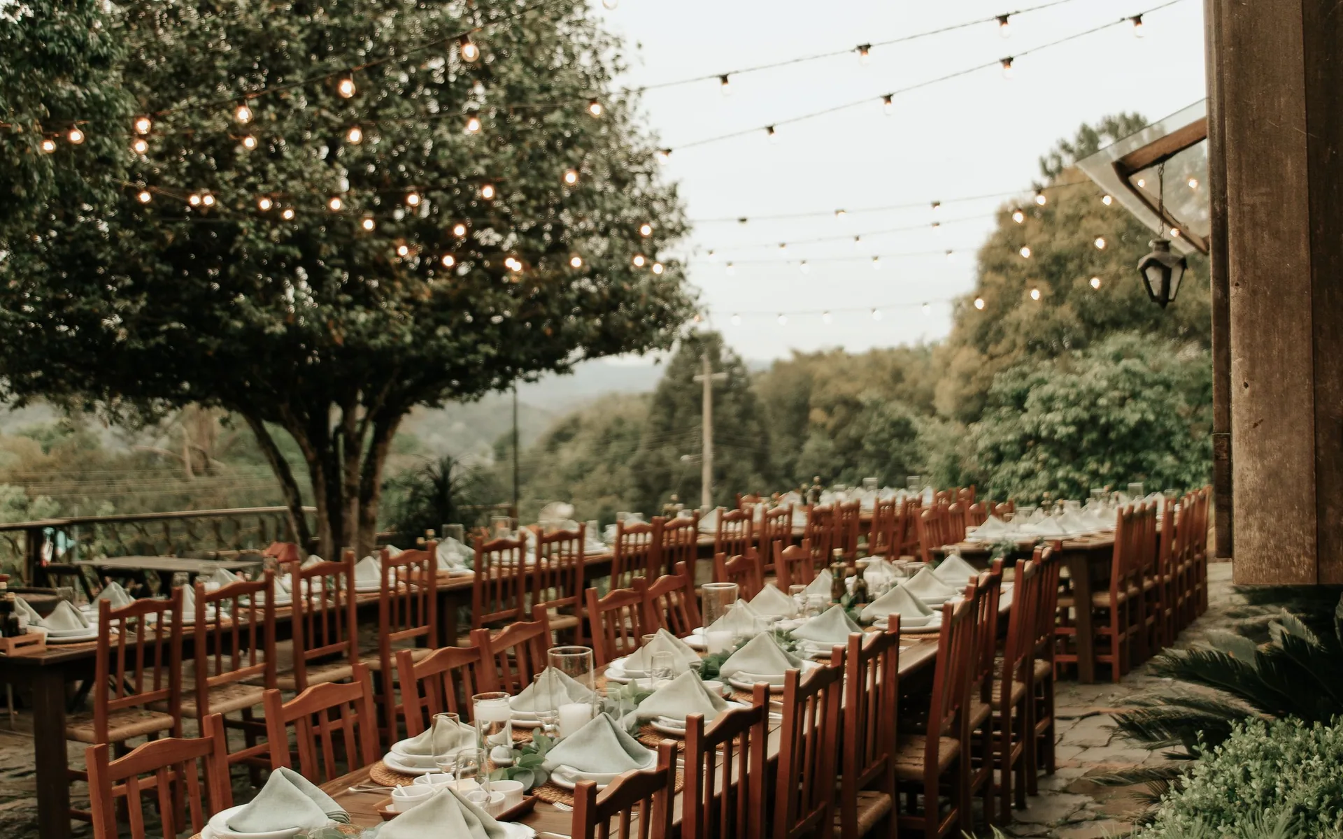Tables de réception et guirlandes lumineuses en plein air, photographie d’inspiration